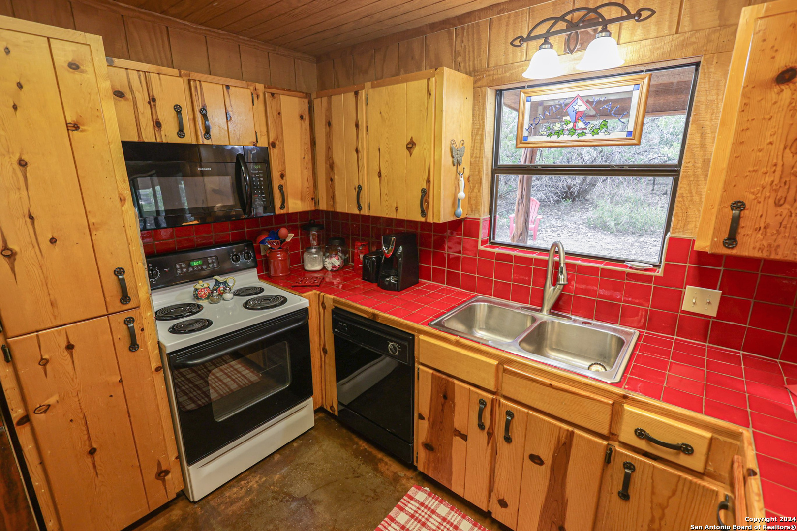 1177 River Road Concan, TX 78838 - Photo 14 of 34 a kitchen with stainless steel appliances a stove a microwave and a window