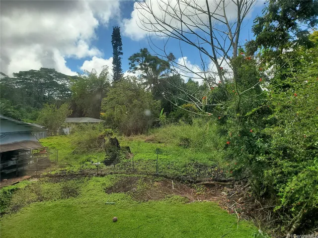 a view of a house with wooden deck and a car parked