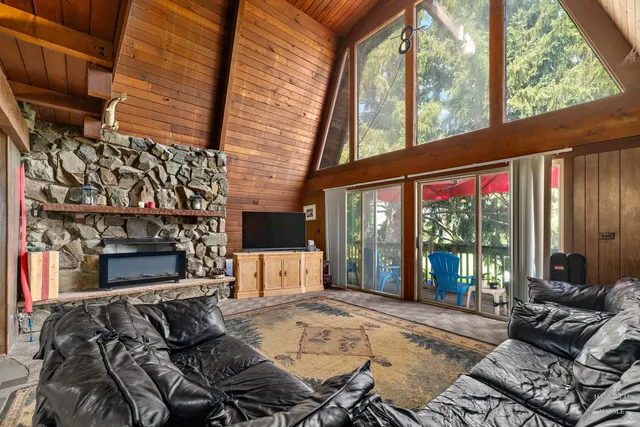a living room with furniture a fireplace and a floor to ceiling window