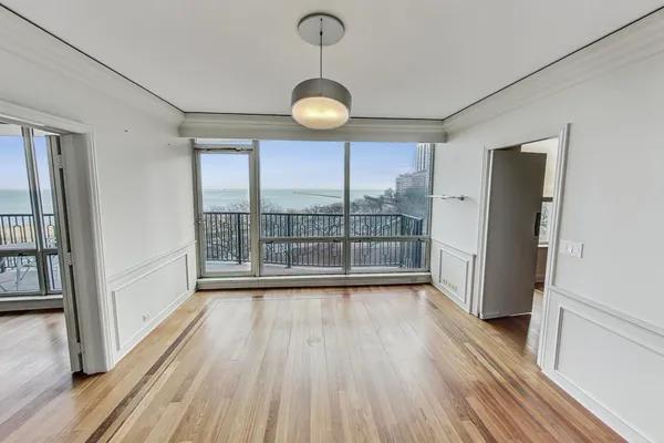 a view of a room with wooden floor fan and window