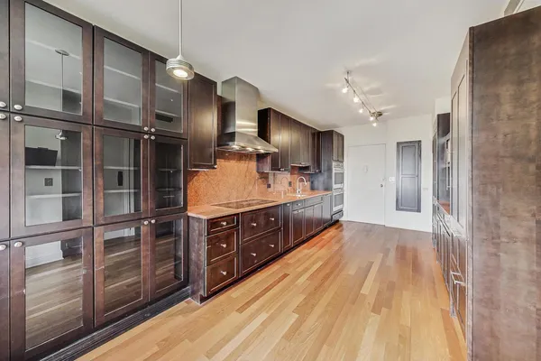 a large kitchen with stainless steel appliances a large counter top a stove and a refrigerator