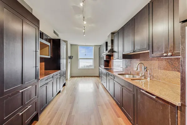 a kitchen with stainless steel appliances granite countertop a sink stove and cabinets