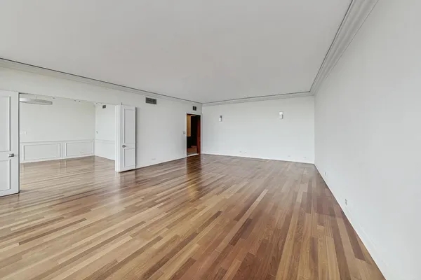a view of an empty room with wooden floor