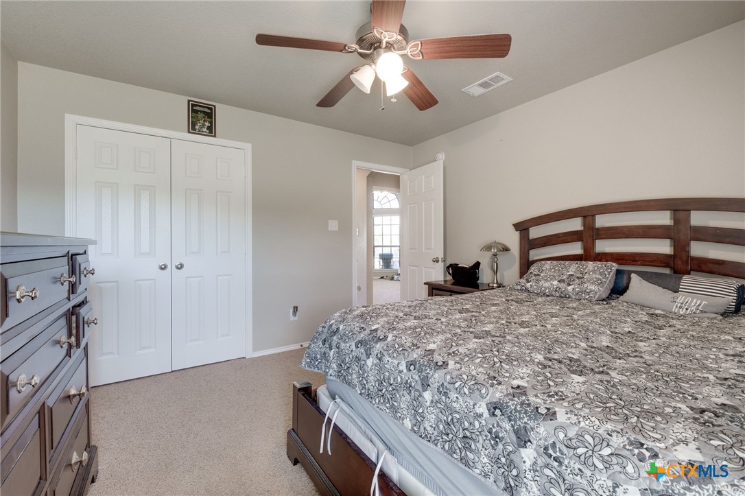 1467 County Road 4820 Kempner, TX 76539 - Photo 16 of 38 a bedroom with a bed and a chandelier