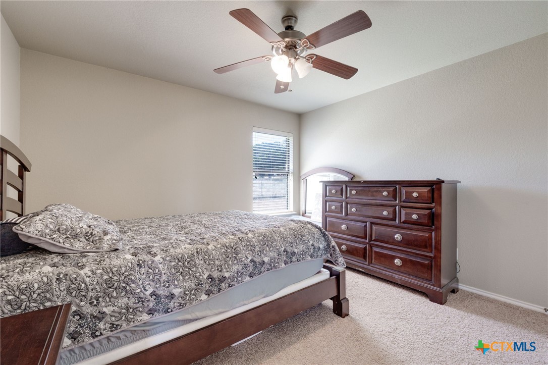 1467 County Road 4820 Kempner, TX 76539 - Photo 17 of 38 a bedroom with a bed and a chandelier