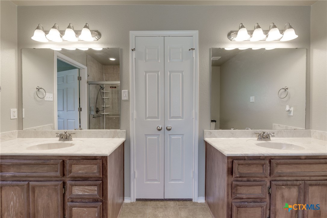 1467 County Road 4820 Kempner, TX 76539 - Photo 21 of 38 a bathroom with a double vanity sink and a mirror