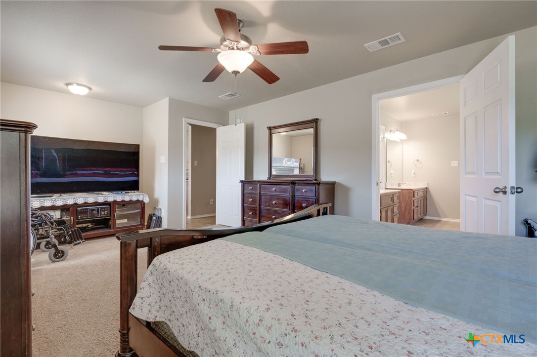 1467 County Road 4820 Kempner, TX 76539 - Photo 23 of 38 a bedroom with a bed and a chandelier