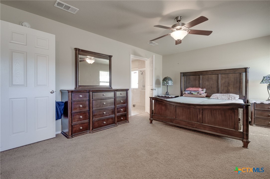 1467 County Road 4820 Kempner, TX 76539 - Photo 24 of 38 a bedroom with a bed and a chandelier