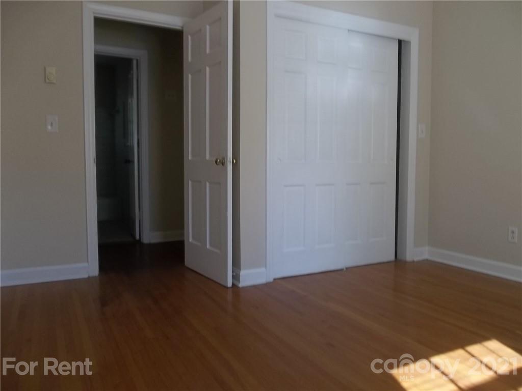 4227 Walker Road, Unit 6 Charlotte, NC 28211 - Photo 5 of 7 an empty room with wooden floor and closet