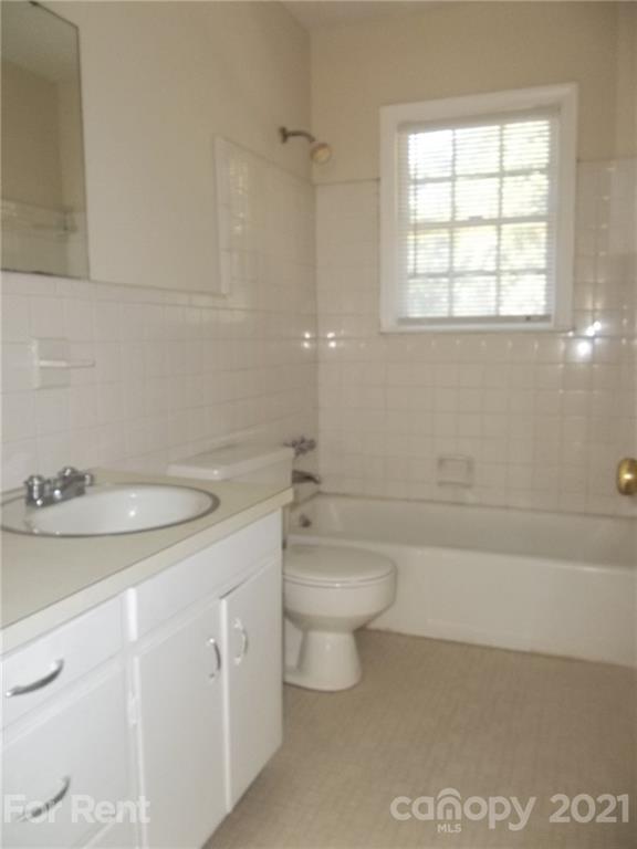 4227 Walker Road, Unit 6 Charlotte, NC 28211 - Photo 6 of 7 a bathroom with a granite countertop sink a toilet and a bathtub
