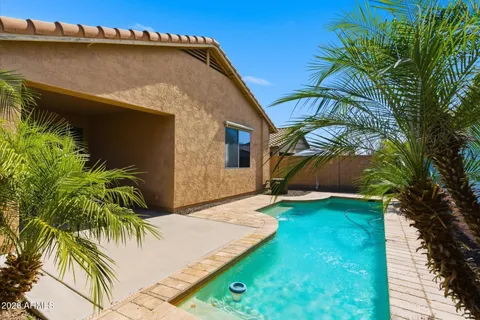a backyard of a house with potted plants and large tree