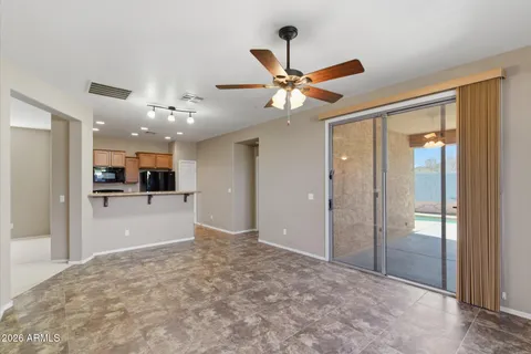 a view of a big room with wooden floor and a kitchen