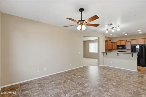 a view of an empty room and a kitchen view