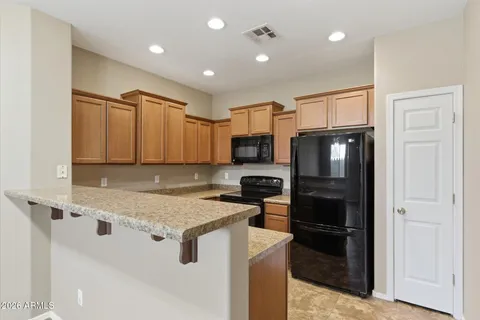a kitchen with stainless steel appliances granite countertop a refrigerator a stove and a sink