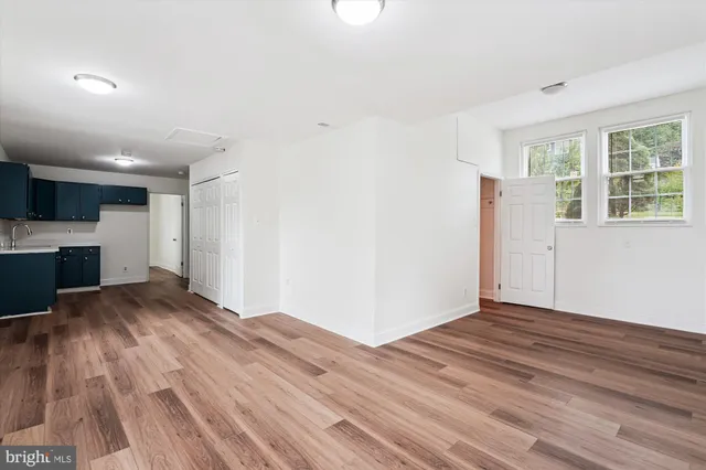 a view of empty room with wooden floor and window