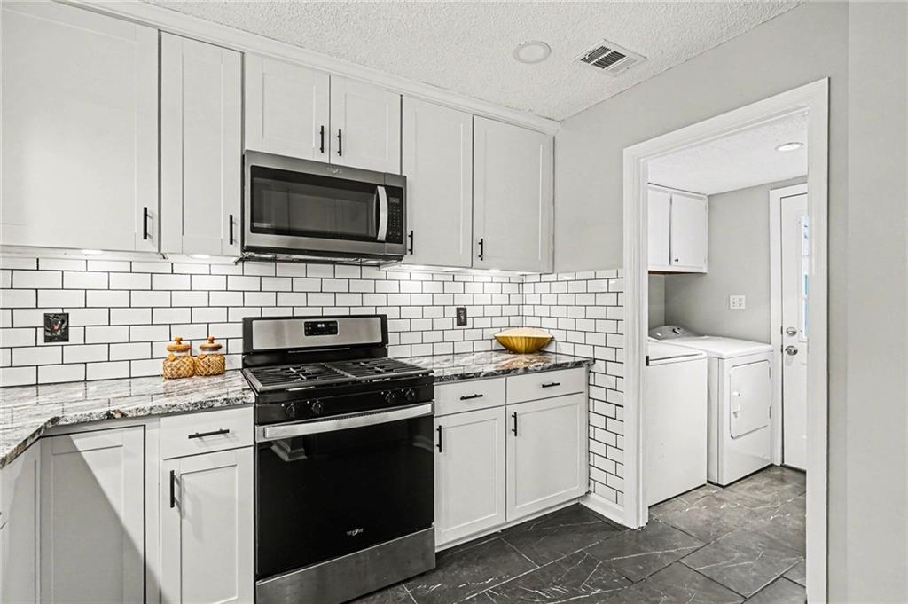 6052 WinterGreen Road Northwest Norcross, GA 30093 - Photo 7 of 24 a kitchen with a sink stove and cabinets