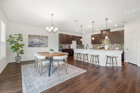 a dining room with furniture a chandelier and wooden floor