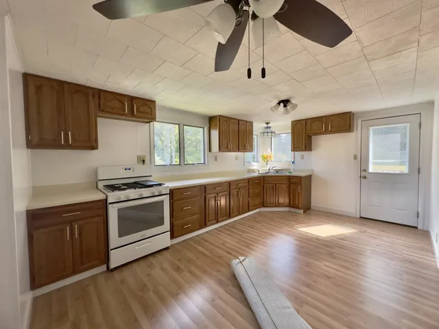 a large kitchen with stainless steel appliances granite countertop a stove a sink and a refrigerator