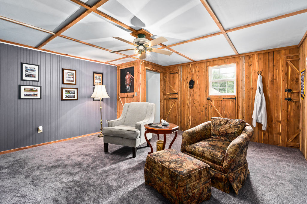 365 Calihan Road Booneville, AR 72927 - Photo 46 of 59 Room featuring wood paneling, beadboard accent wall, gray carpeting, and a ceiling fan