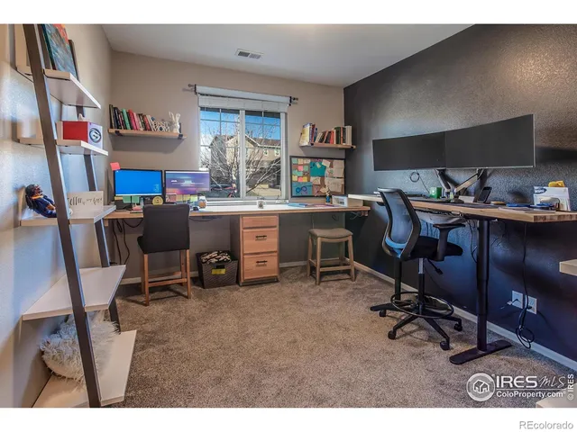 a view of a workspace with furniture and a window
