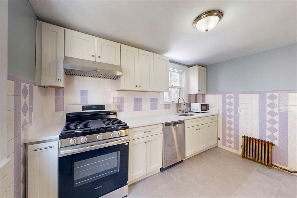 5 Alcott Street Boston, MA 02134 - Photo 4 of 36 a kitchen with stainless steel appliances white cabinets and a stove top oven