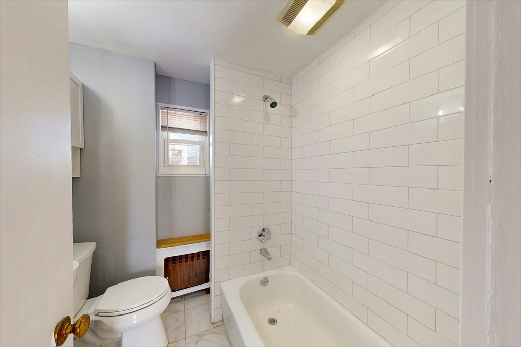5 Alcott Street Boston, MA 02134 - Photo 9 of 36 a bathroom with a bathtub and toilet