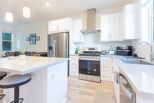 a kitchen with granite countertop a sink stove and refrigerator