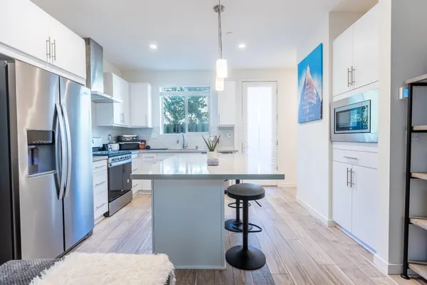 a kitchen with stainless steel appliances a sink cabinets and wooden floor