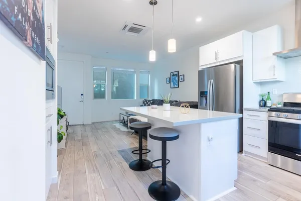 a kitchen with kitchen island a sink stainless steel appliances and cabinets