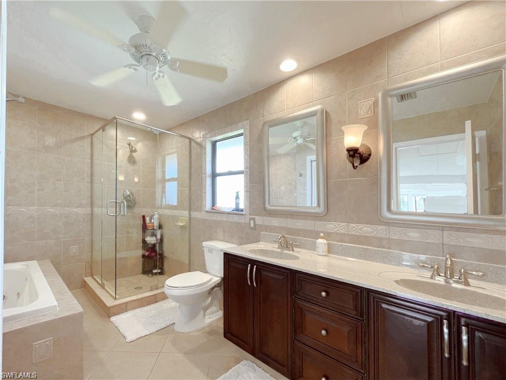 110 June Court Marco Island, FL 34145 - Photo 16 of 31 a spacious bathroom with a double vanity sink toilet mirror and shower