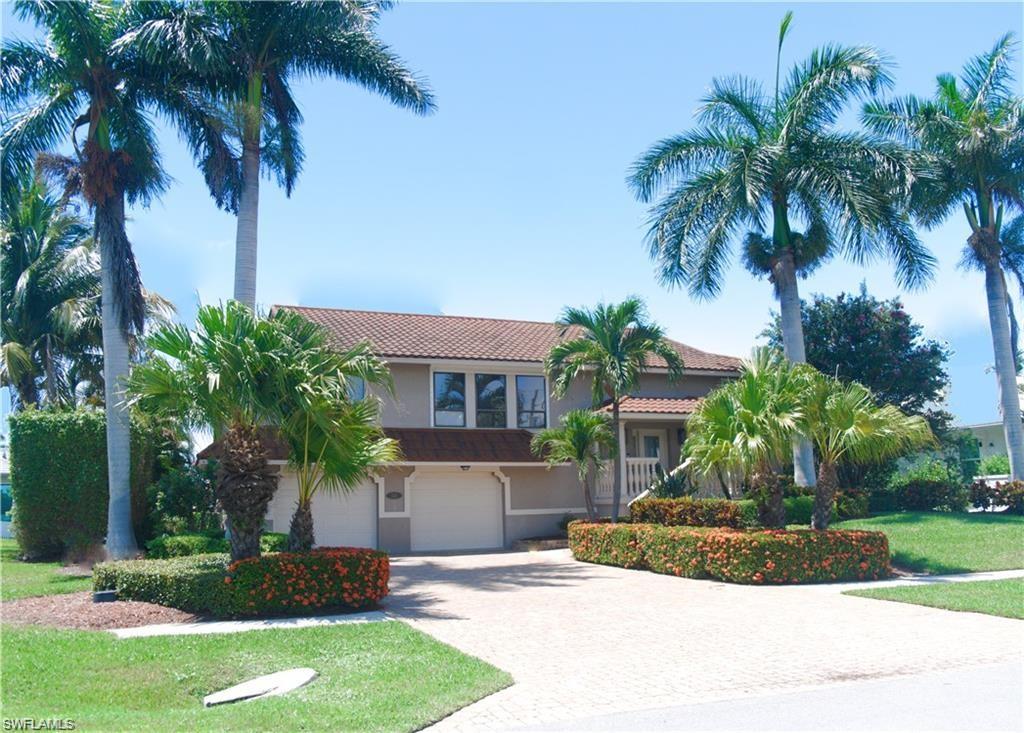 110 June Court Marco Island, FL 34145 - Photo 2 of 31 a view of a house with a yard and palm trees