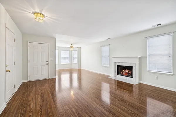 a living room with wooden floor and a fireplace