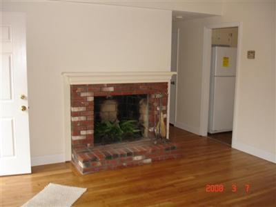 Undisclosed Address Harwich, MA 02645 - Photo 2 of 9 a view of an empty room with wooden floor and a fireplace