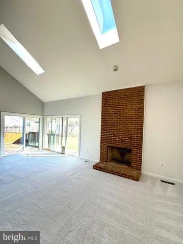 an empty room with windows and fireplace
