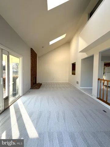 a view of a big room with wooden floor and windows