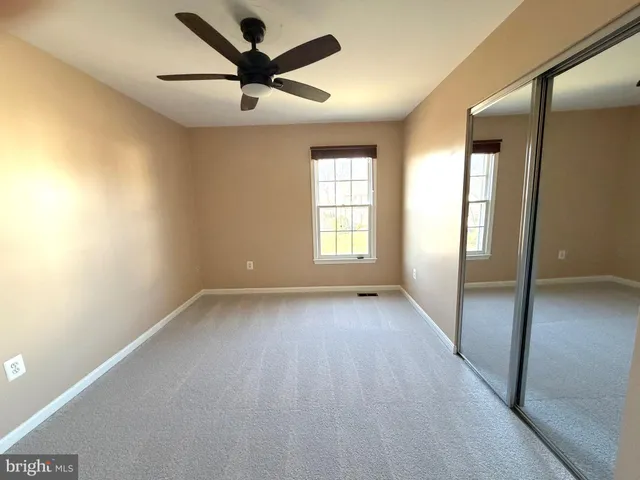 a view of a livingroom with a ceiling fan and window