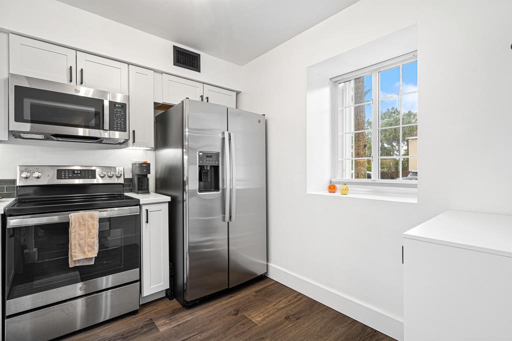 4620 West McNab Road, Unit B1 Pompano Beach, FL 33069 - Photo 13 of 36 a kitchen with stainless steel appliances a stove a microwave and a refrigerator