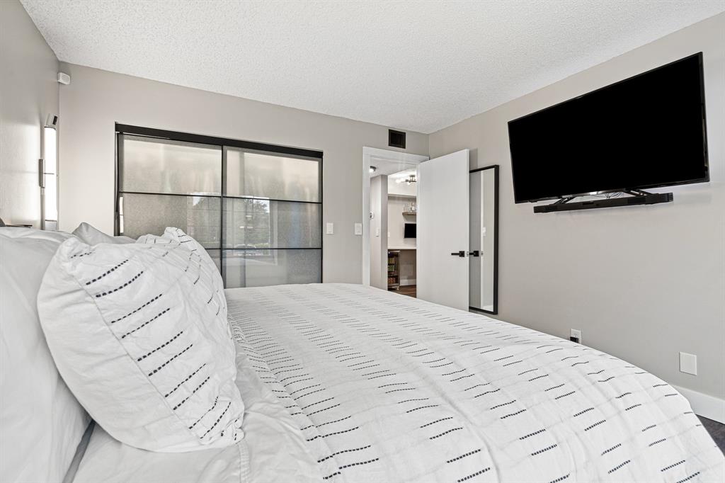 4620 West McNab Road, Unit B1 Pompano Beach, FL 33069 - Photo 24 of 36 a bedroom with a large bed and a flat screen tv