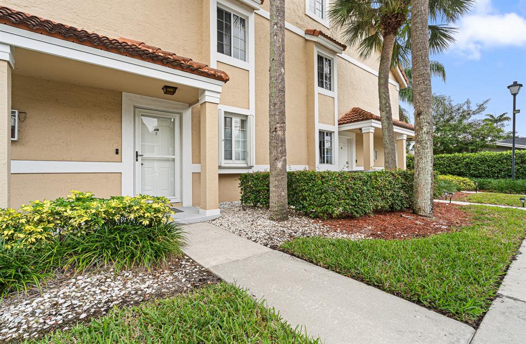 4620 West McNab Road, Unit B1 Pompano Beach, FL 33069 - Photo 30 of 36 a front view of a house with a yard and plant