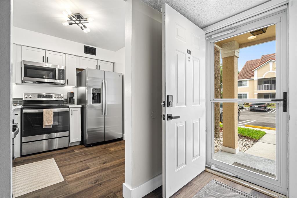 4620 West McNab Road, Unit B1 Pompano Beach, FL 33069 - Photo 4 of 36 a kitchen with stainless steel appliances granite countertop a refrigerator and a stove top oven
