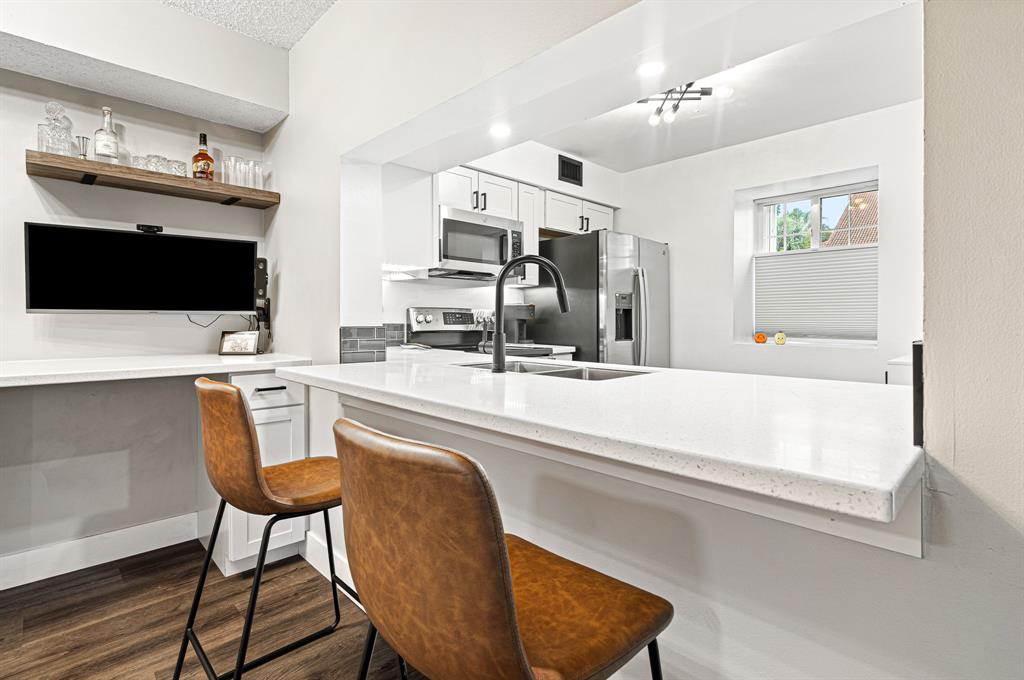 4620 West McNab Road, Unit B1 Pompano Beach, FL 33069 - Photo 10 of 36 a kitchen with a stove a sink and a microwave