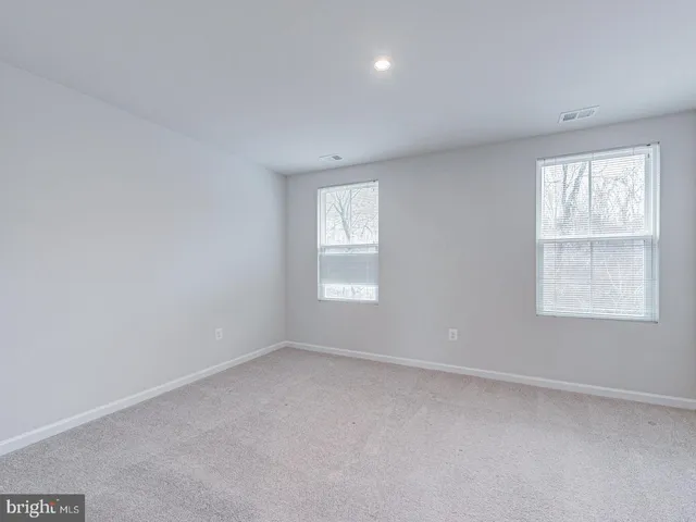 a view of an empty room with a window and bathroom