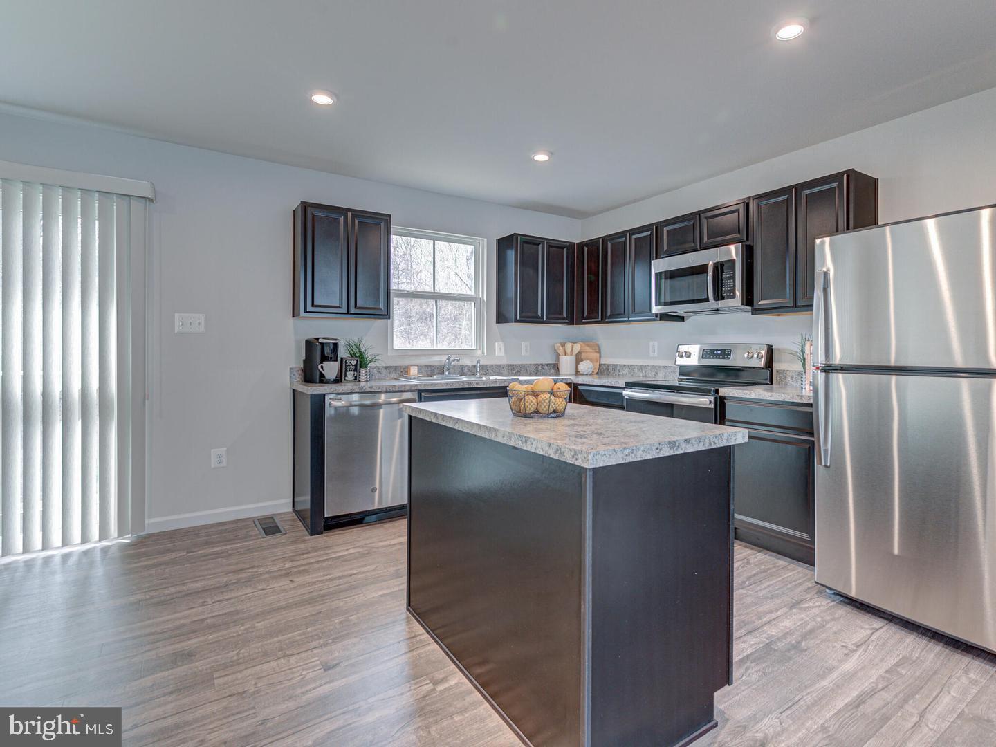 290 Sage Circle Winchester, VA 22603 - Photo 3 of 31 a kitchen with kitchen island a refrigerator stove and sink