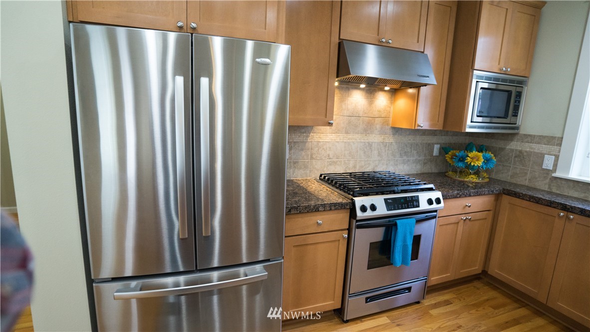 662 Lyons Avenue Northeast Renton, WA 98059 - Photo 9 of 28 a kitchen with stainless steel appliances a refrigerator a stove and cabinets