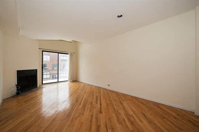 944 West Grace Street, Unit E202 Chicago, IL 60613 - Photo 2 of 10 a view of an empty room with wooden floor and a window