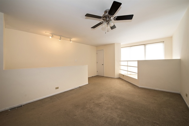 944 West Grace Street, Unit E202 Chicago, IL 60613 - Photo 8 of 10 en empty room with windows and ceiling fan