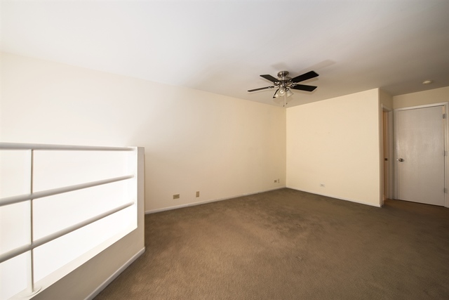 944 West Grace Street, Unit E202 Chicago, IL 60613 - Photo 9 of 10 an empty room with a ceiling fan and a window