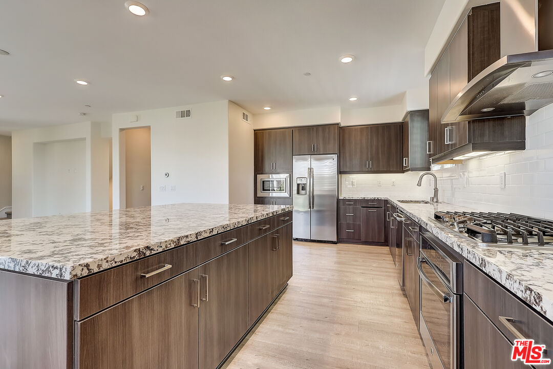 202 Paramount Irvine, CA 92618 - Photo 17 of 32 a kitchen with stainless steel appliances granite countertop a sink stove and refrigerator
