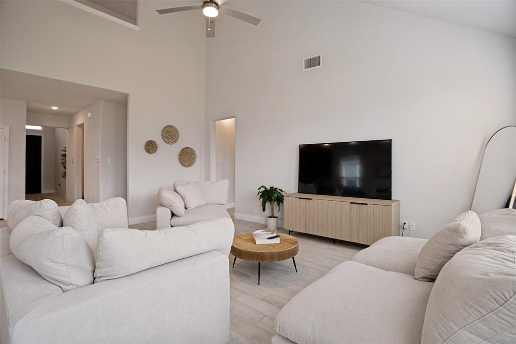 3115 Giovanni Point Princeton, TX 75407 - Photo 5 of 26 Spacious living area featuring vaulted ceilings, light-toned wood-finish flooring, a contemporary ceiling fan, recessed lighting, and a built-in media console