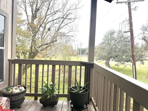 a view of a balcony with chairs and a potted plant